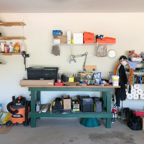 Garage with cluttered work bench and storage wall