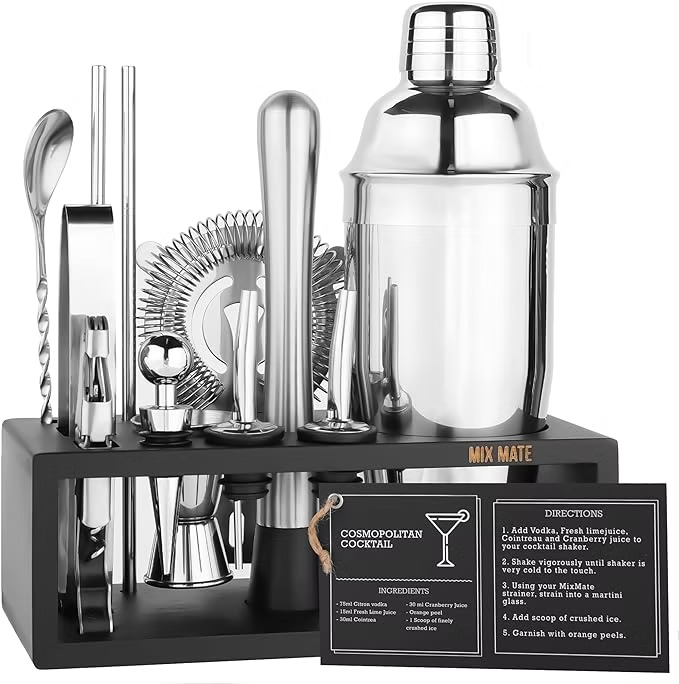 Cocktail shaker set in a black stand with spoons, jigger, strainer, and recipe cards labeled Mix Mate and Cosmopolitan Cocktail.