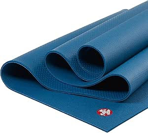 Blue yoga mat rolled up with a red logo, showcasing textured surface. It's placed on a plain, light background.