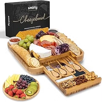 Cheese board gift set with wooden tray, cheeses, grapes, crackers, nuts and utensils beside a black Smirly box.