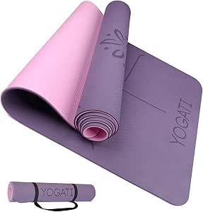 Purple and pink yoga mat, partially rolled with "YOGATI" text. Floral pattern visible. Separate rolled-up mat shown with black strap.