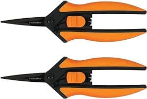 Two pairs of orange and black pruning shears with sharp blades on a white background. The brand "Fiskars" is visible on the handles.