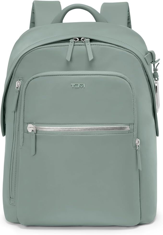 Sage green TUMI backpack with zip pockets and top handle, shown front-facing on a white background.