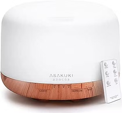 White ASAKUKI essential oil diffuser with wood-grain base and remote control on a plain white background