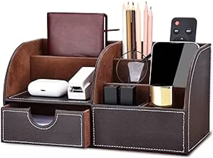 Brown leather desk organizer with drawers holding phone, pencils, glasses, earbuds, and a remote on a white background