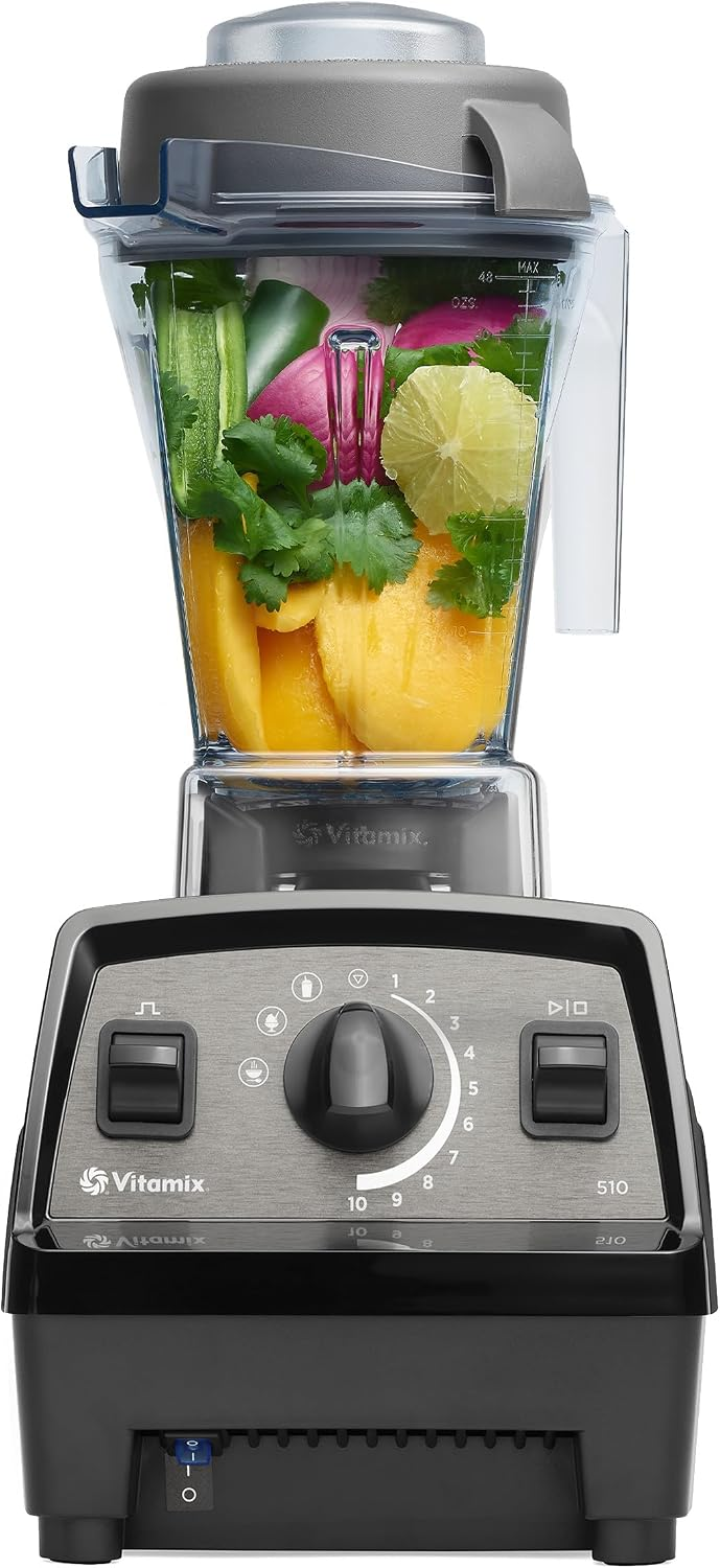 Vitamix blender filled with mango, cucumber, lime, onion, and cilantro; control dial and logo visible on black base.