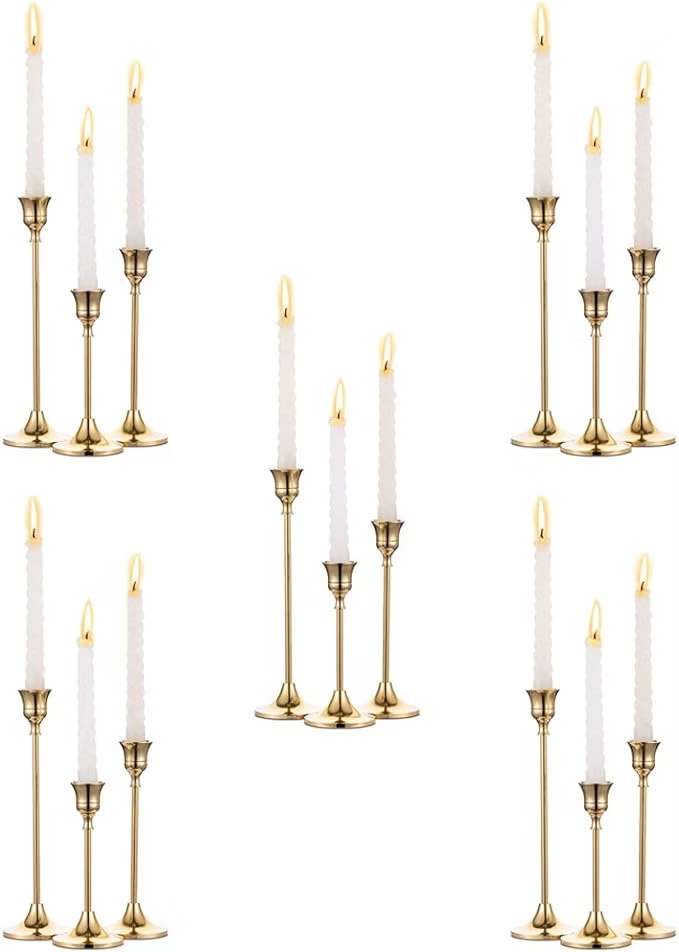 Five gold candle holders with tall white candles on a white background, arranged in a repeating pattern.