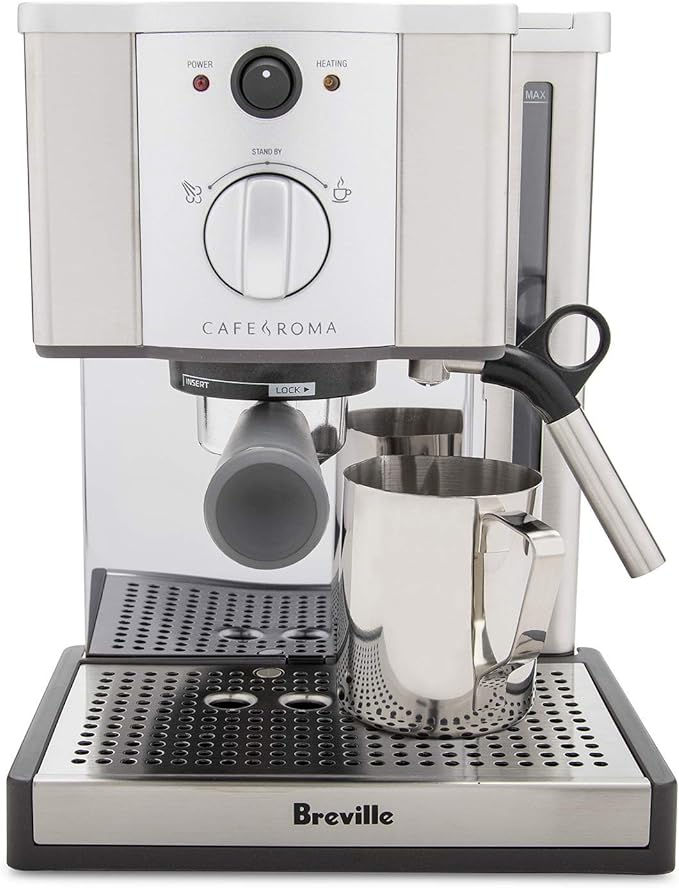 Silver espresso machine with milk frothing pitcher on drip tray. Features "Breville" and "Café Roma." Power and heating lights visible.