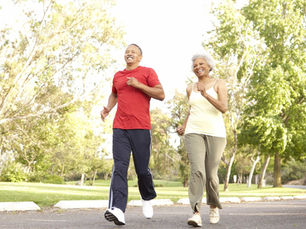 A healthy older couple running down a road, presumably after vein treatments.