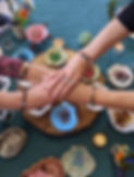 Four friends placing their hands on top of each other, showing their Life Beading bracelets