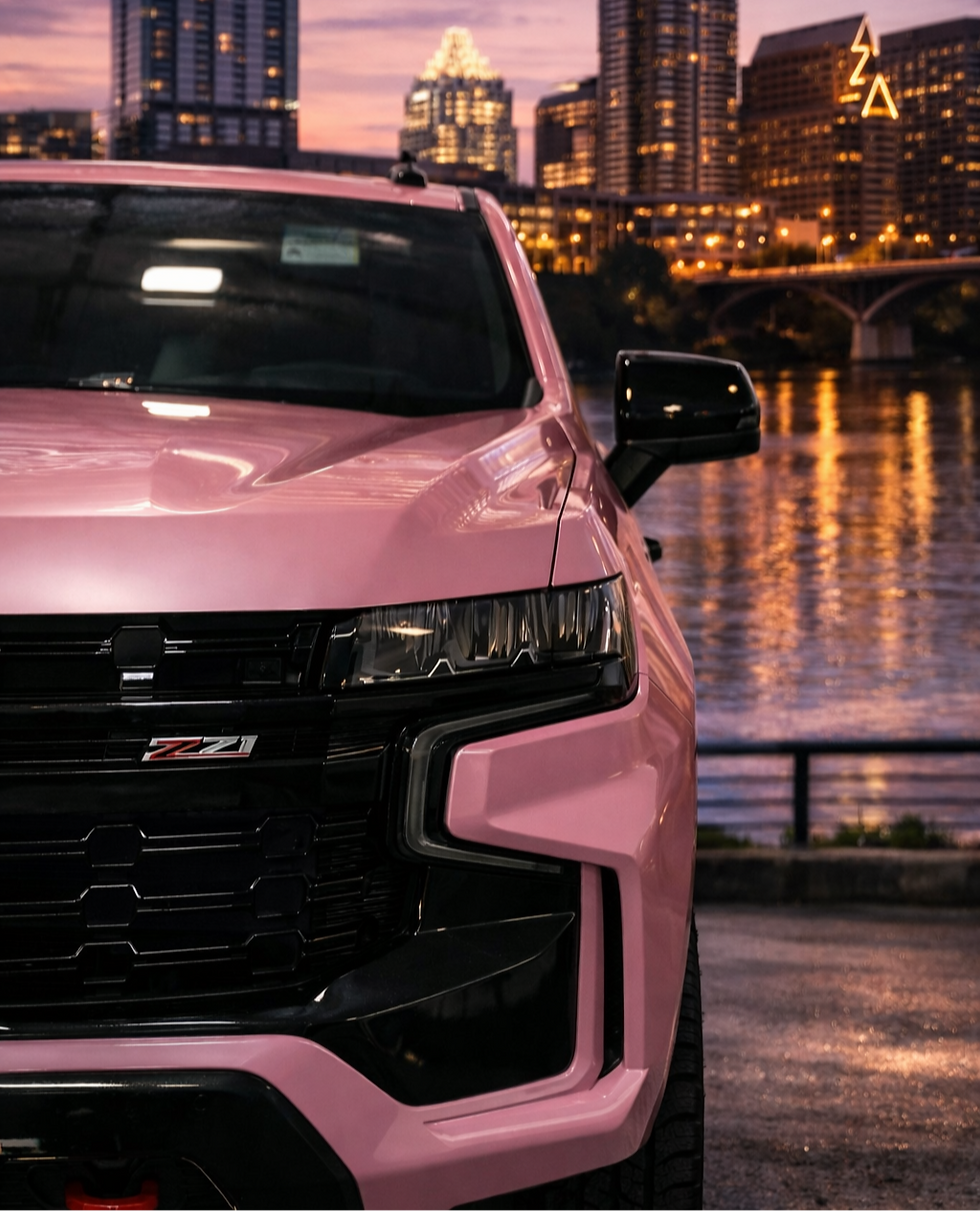 High angle view of a female chauffeur opening the door of a pink luxury car