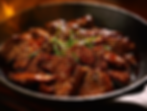 A plate of Beef Teriyaki garnished with sesame seeds and green onions.