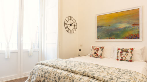 a bedroom with a bed and a clock on the wall
