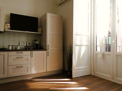 a kitchen with white cabinets and a black flat screen tv