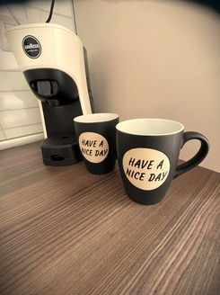 two black coffee mugs that say have a nice day