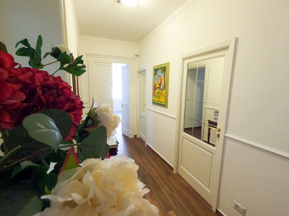 a hallway with flowers and a painting on the wall