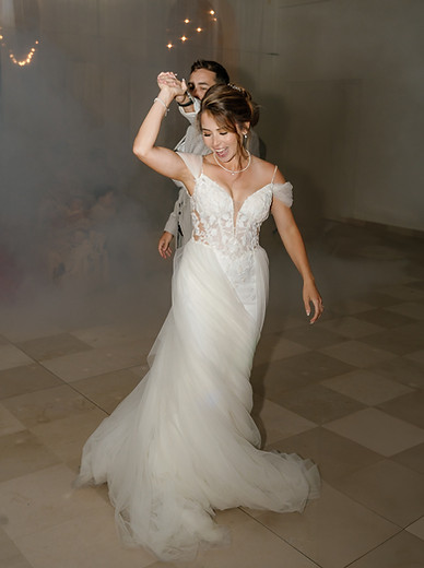 Brautpaar bei ihrem First Dance im Chateau de Varennes in Frankreich. Die Braut dreht sich lachend, im Hintergrud hat es Nebel einer Nebelmaschine