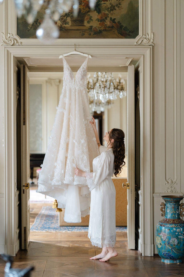 Kleid hängt in einem Raum der St Charles Hall und Braut steht daneben