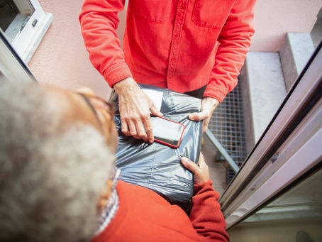person receiving package at door representing Rogers iPad scam where fraudsters trick Canadian customers into financing tablets through fake promotions