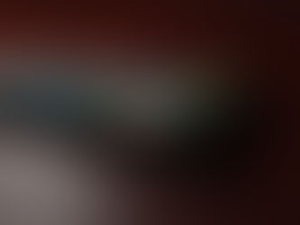 Android smartphone displaying Google app icons including Gmail, lying flat on a dark red surface