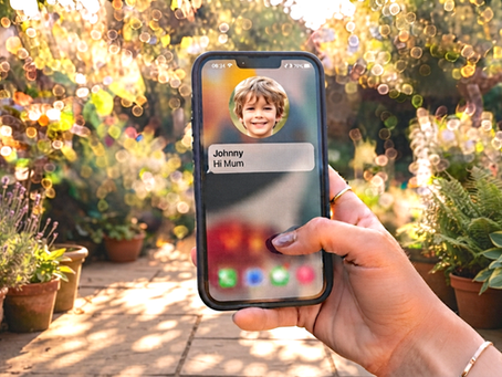 A hand holding a smartphone displaying a "Hi Mum" text message notification from a contact named Johnny, set against a warm, sunny garden background, illustrating the heatwave-themed Hi Mum text scam targeting parents this summer