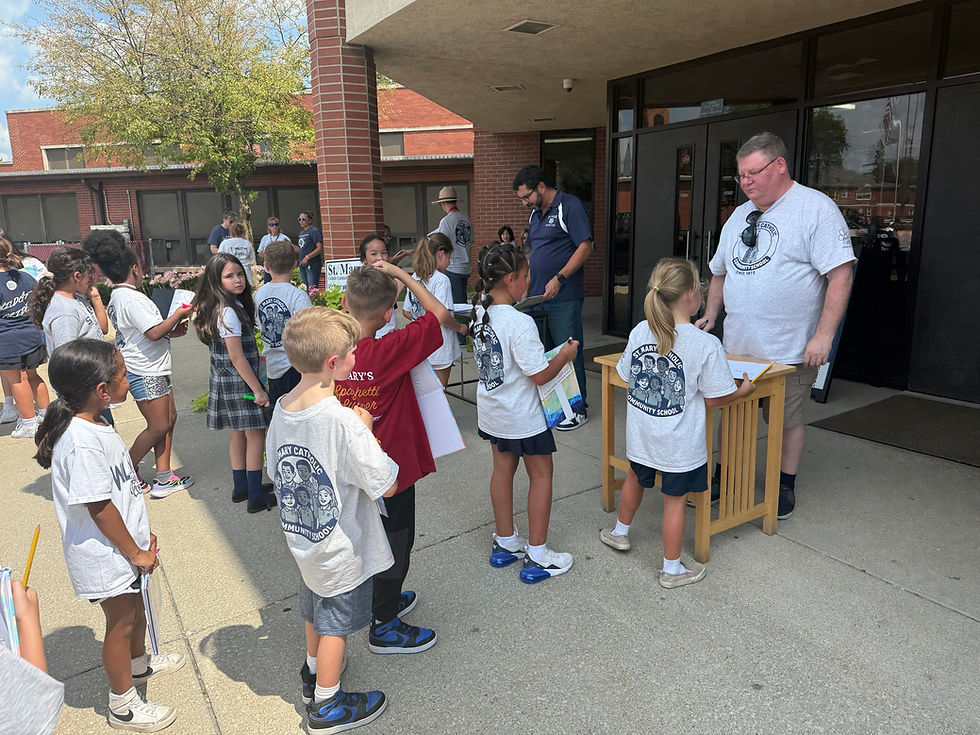 Principal Tom Ruiz, Fr. Peter Muha signing yearbooks.