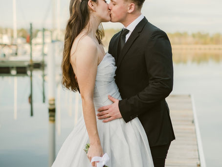 Couple sharing a kiss at their elopement while standing on a dock in a marina