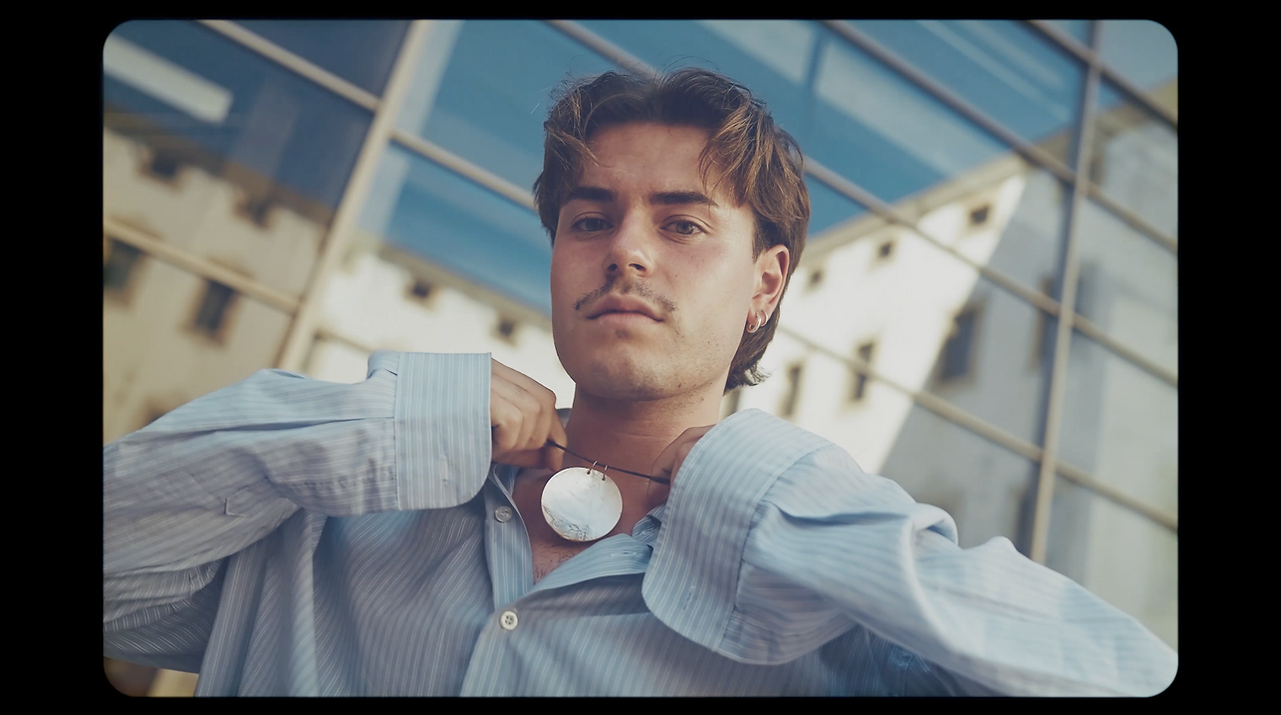 Color-graded portrait of a man standing in front of a light-colored building, part of a video editing portfolio.