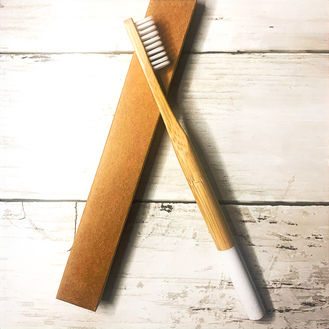 Bamboo toothbrush displayed on the product's  minimalistic package