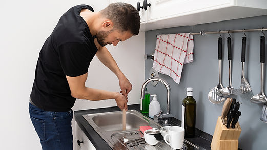 Man unblocking a blocked drain