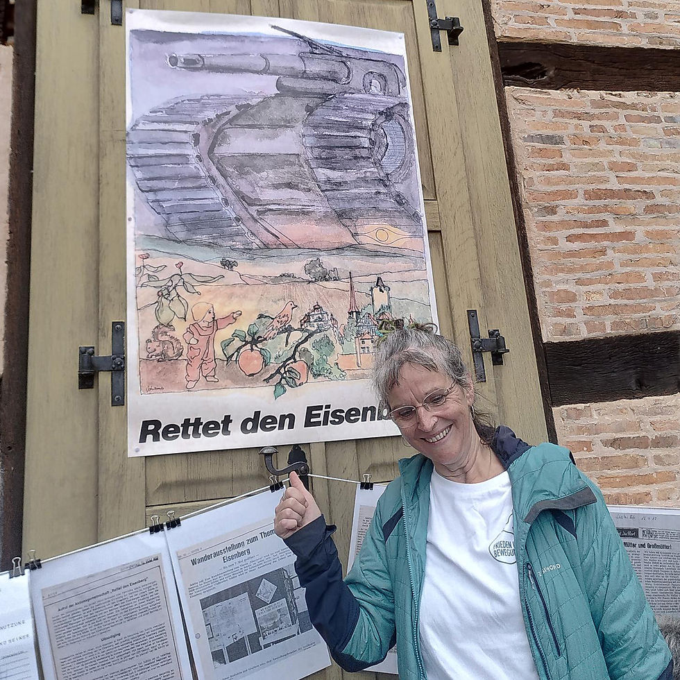 Auf der Großen Eisenwiese gab es viele Informationen zum Kampf um den Eisenberg. Hier Gudrun Gabriel vor dem Plakat "Rettet den Eisenberg".