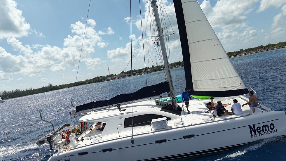 Catamaran Nemo sailing along the Cozumel coastline with guests relaxing on deck