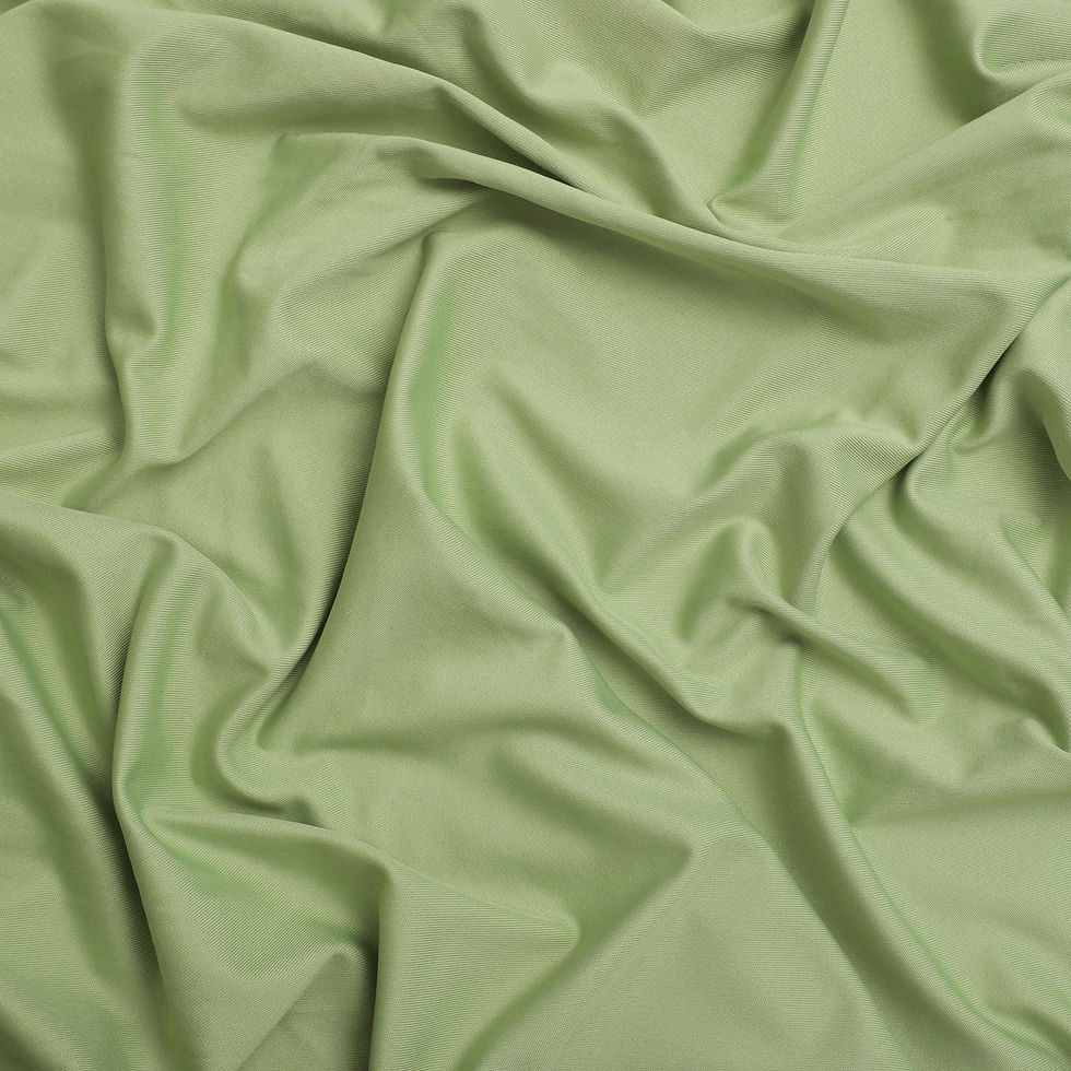 Green fabric with soft folds, showing texture and light reflection.