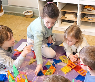 Des enfants travaillant ensemble sur une activité de construction en classe de maternelle à l'École Saint-Joseph
