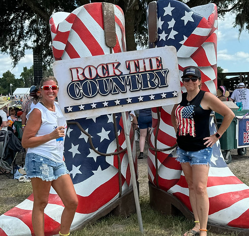 Colleen and Kimberly at Rock the Country festival posing by star-spangled cowboy boots