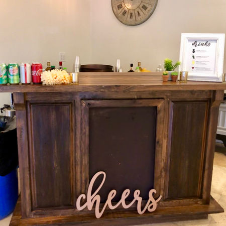 An indoor bar all setup with signage, available drinks, and decor