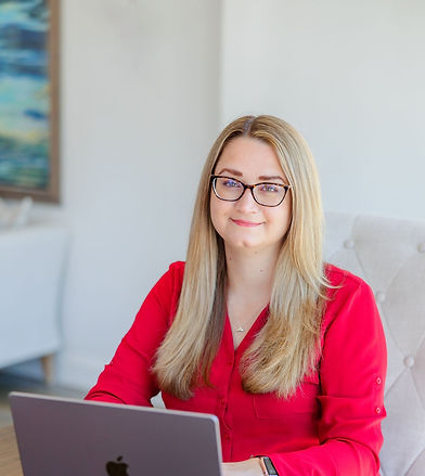 Dr. Stephanie Brown, Executive Coach, sitting at a table in front of her laptop waiting to review your interest form