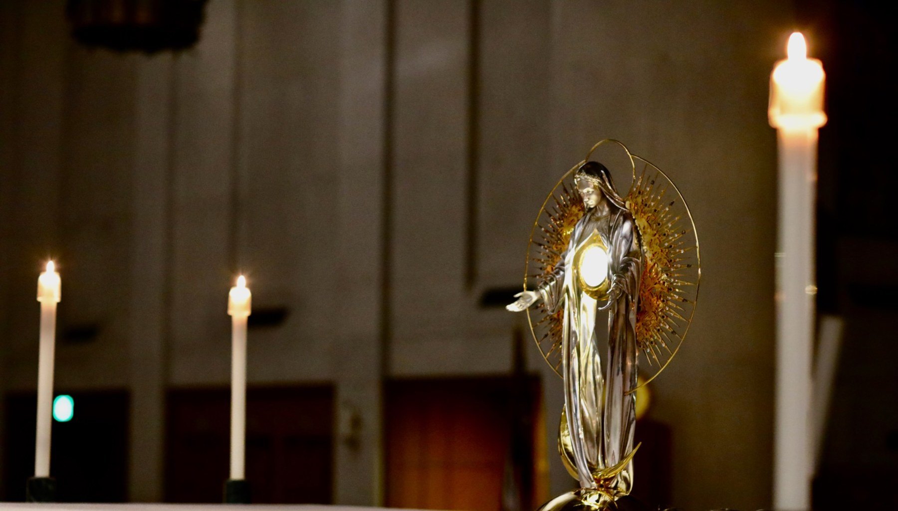 Marian monstrance on the altar between lit candles