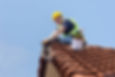 construction worker performing roof repair on a tiled roof