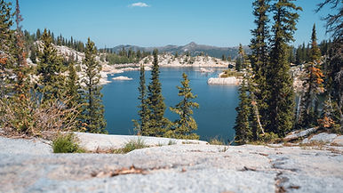 Serene View Of Lake Mary Framed By Trees And Rocks Reflecting Nature’s Calmness