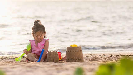 kid having fun building sandcastle on beach