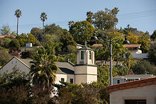 Small white church tower nestled among green trees