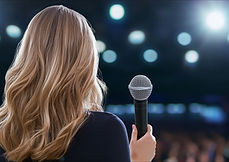 woman standing in front of the crowd for a speech
