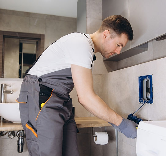 professional plumber working on concealed toilet cistern in modern bathroom