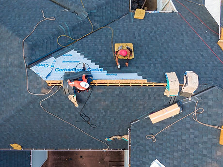 workers int the process of application of protective underlayment for new roof installation