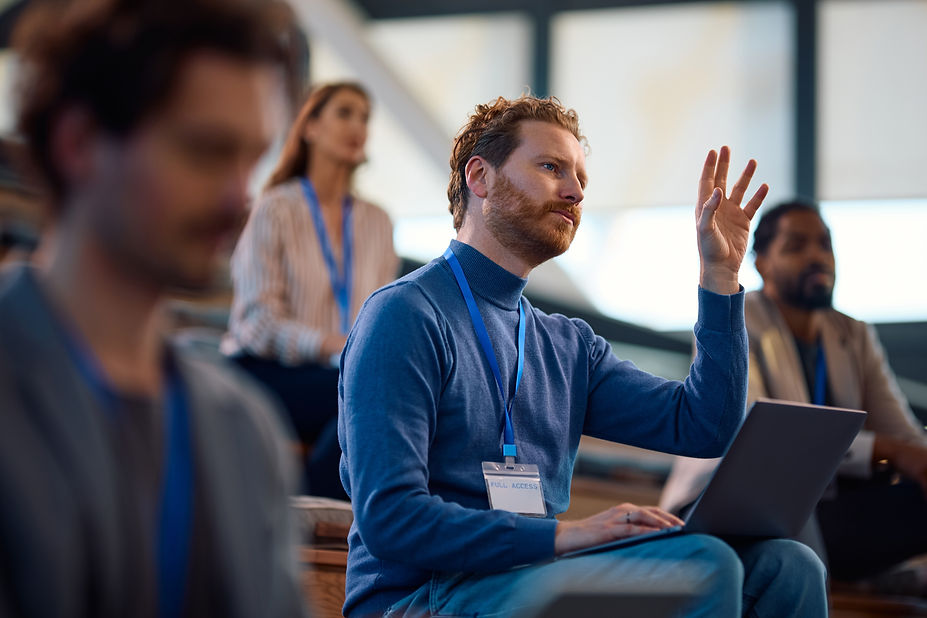 man raising hand to ask question