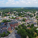 Aerial View Of Downtown Methuen With Brick Mill Buildings, River, Bridge, And Tree-Lined Streets