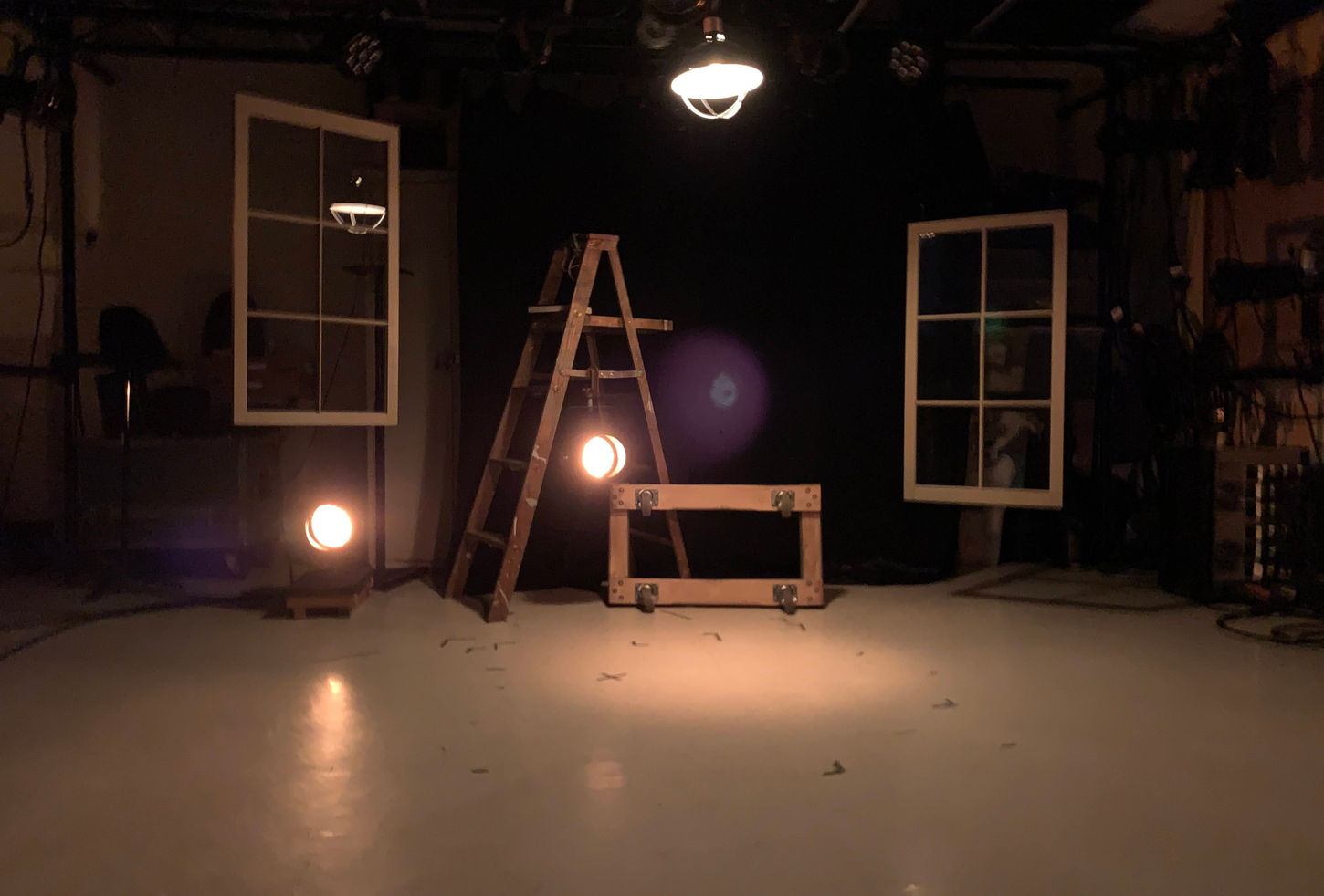 Rustic scene, hanging windows and lighting fixtures, lighting fixtures aimed at camera hanging off ladder