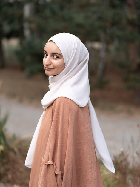 Portrait d’une femme voilée aux couleurs pastel, au regard doux et serein.
