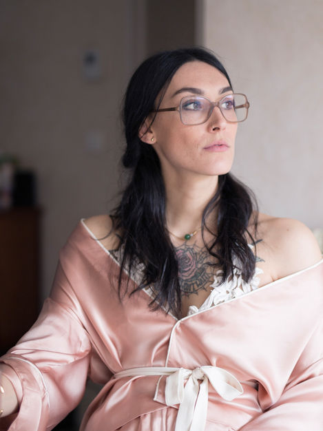 Portrait délicat et frais d’une femme brune pensive, vêtue d’un kimono rose avec sous-vêtements brodés.